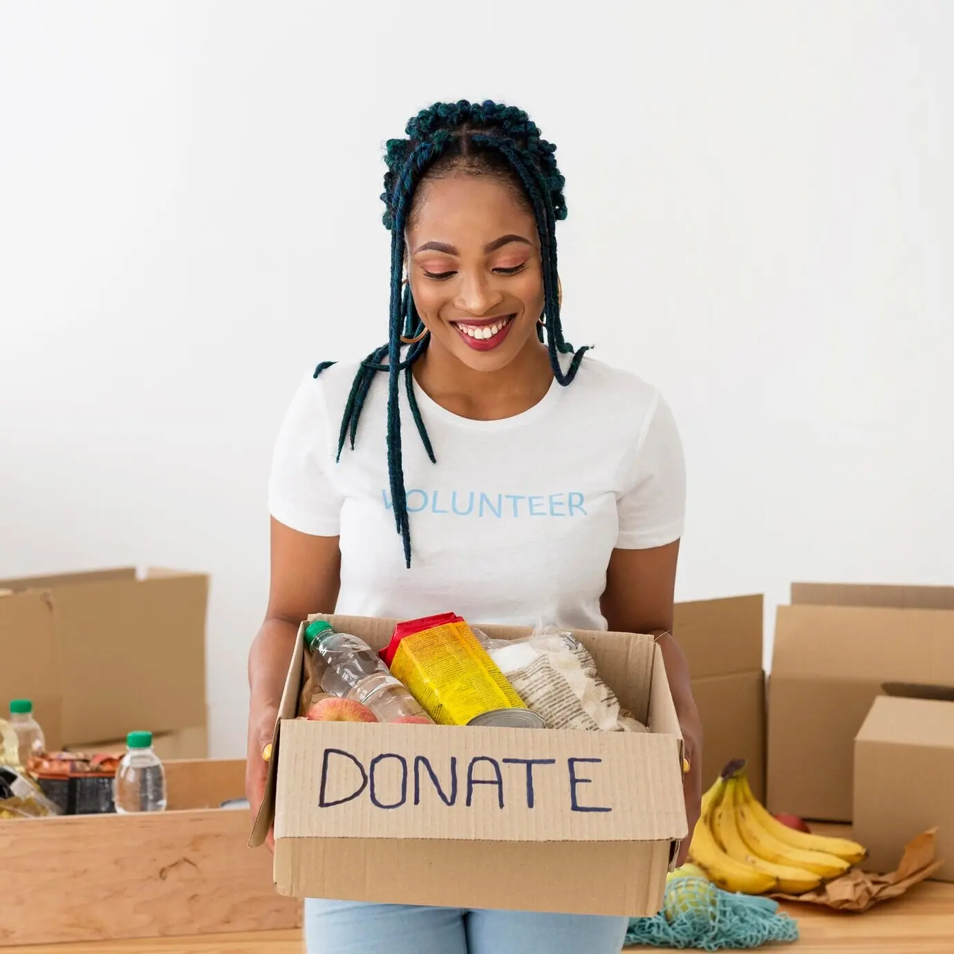Mujer sonriente sosteniendo una caja de donaciones